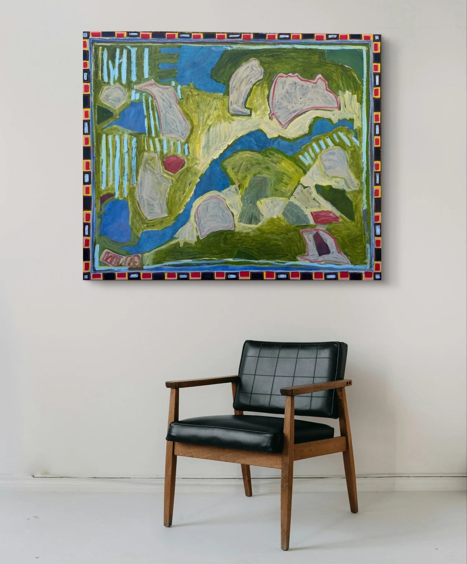 Abstract painting on a wall above a black armchair