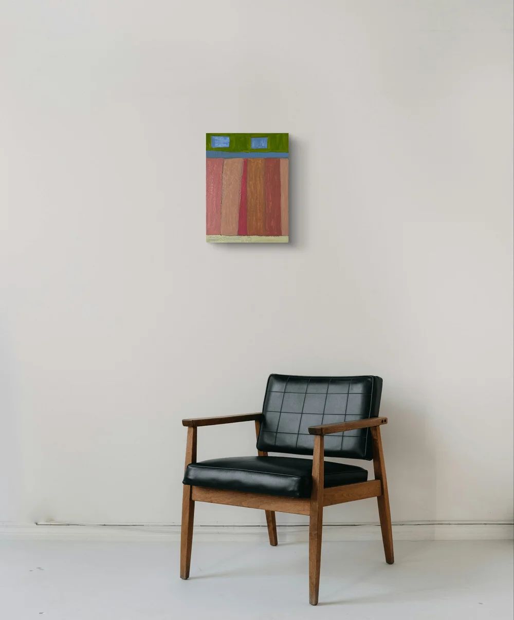 Black armchair in front of a wall with a colorful abstract painting