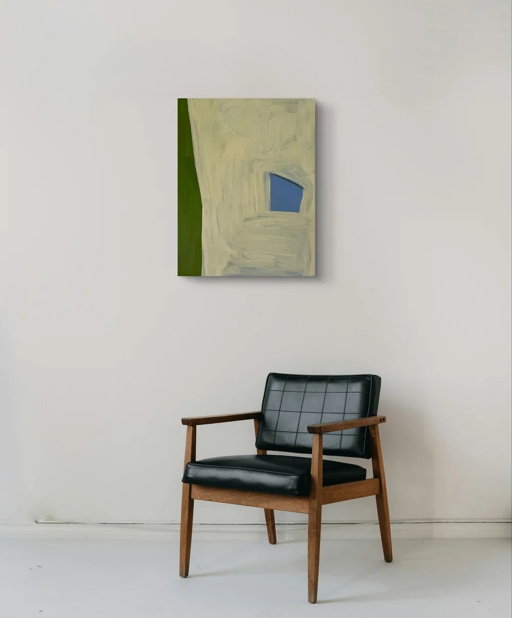 Black armchair in front of a wall with a abstract painting
