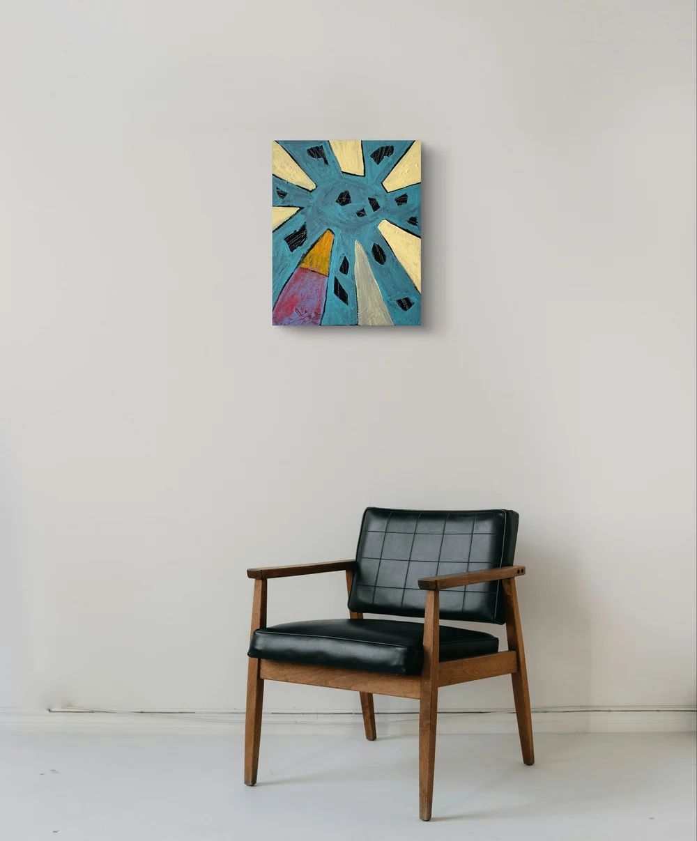 Abstract painting on a wall above a black chair with wooden frame.