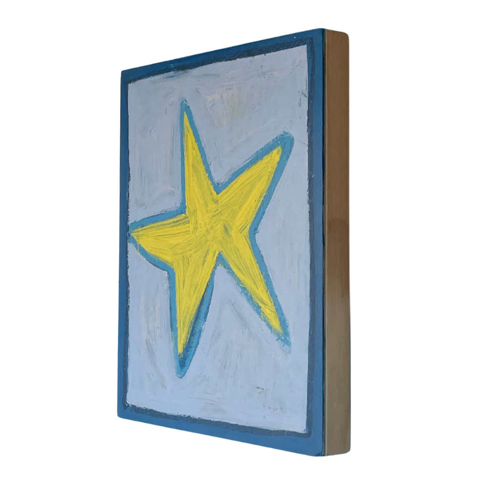 A square canvas wall art piece shown at an angle, featuring a yellow star outlined in blue on a light blue background, with a dark blue border and a brown side edge, set against a light blue background.