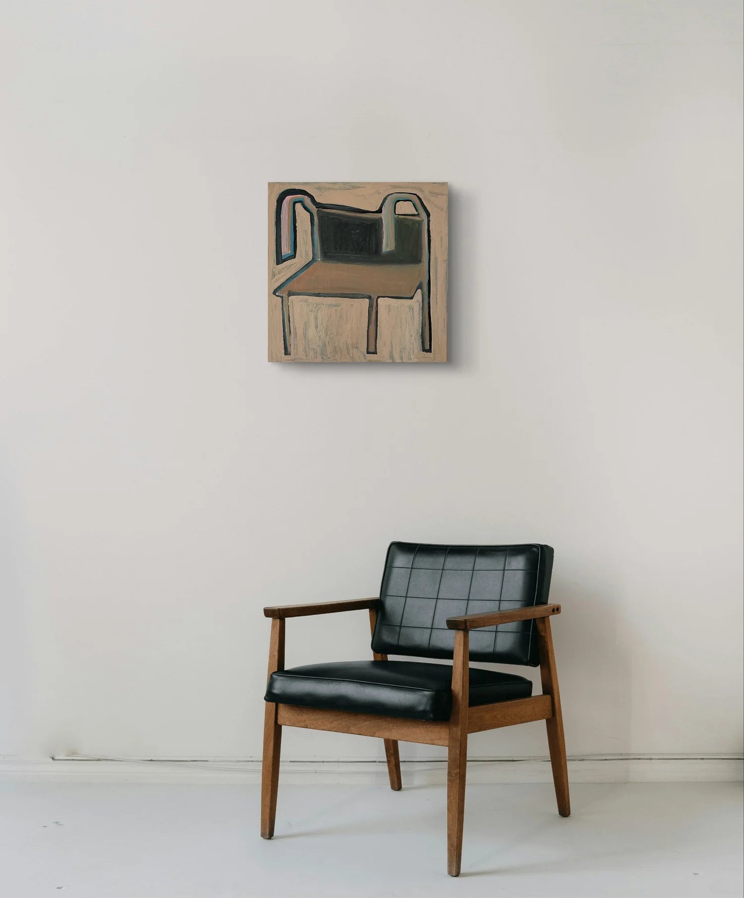 Have A Seat painting by Marley Alvarez. Black leather armchair in front of a wall with a framed abstract painting.